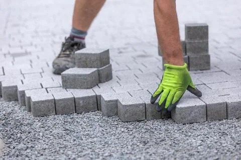 Process of building sidewalk, worker laying interlocking walking path Stock Photos