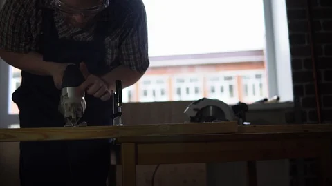 The process of building a wooden table, the carpenter saws out the details. Stock Footage 90742630