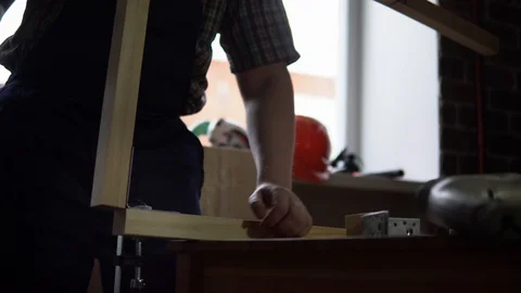 The process of building a wooden table, the carpenter collects the base. Stock Footage 90800792