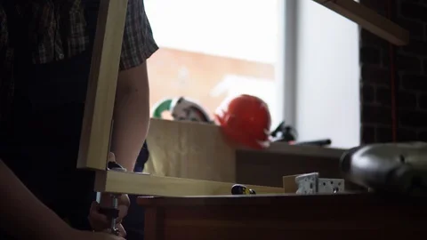 The process of building a wooden table, the carpenter collects the base. Stock Footage 90800799