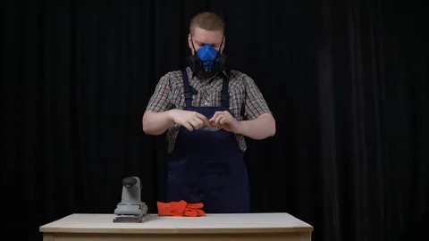 The process of building a wooden table, the carpenter puts on protective glasses Stock Footage 91734282