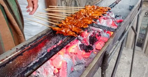 The process of burning satay chicken meat savory with spicy seasonings on the Stock Photos