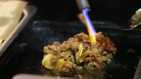 The process of burning the Yakiniku or terayaki meat while stirring it Stock Footage 265675217