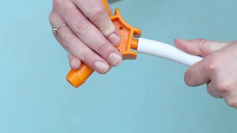 Process of calibrating plastic pipe with orange hand tool Stock Footage 338016132