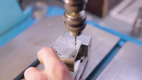 The process of carefully drilling a hole in metal Stock Footage 314382368