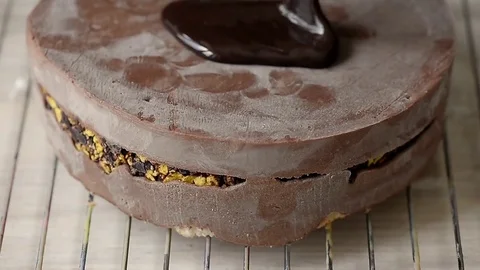 The process of casting the mirror glaze on a cake round session. Mousse. Brown Stock Footage 76940480