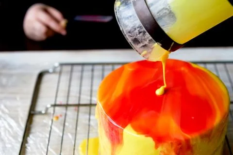 The process of casting the mirror glaze on a cake round session. Mousse.Yellow Stock Photos