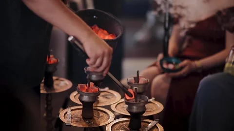 Process of changing burned embers in hookah to the new one coals. Smoking shisha Stock Footage 234754339