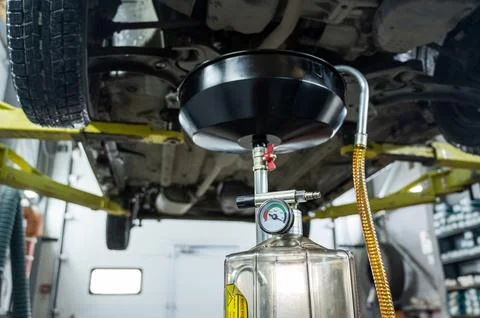 The process of changing the oil in a car engine. Draining old dark used oil from Foto stock