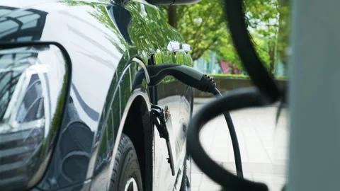 Process of charging dark electric car at vehicle charging point Video stock 242312703