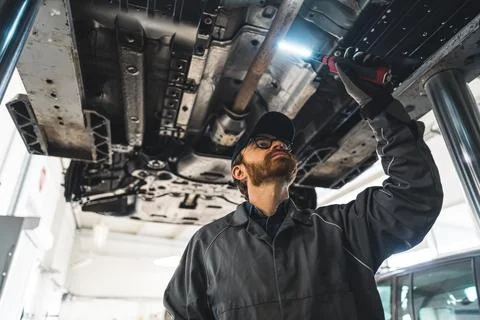 Process of chassis inspection, mechanic checking a car with a diagnostic tool Stock Photos