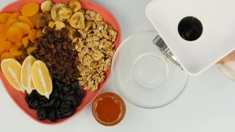 Process of chopping nuts with lemon on a electric grinder, fruit mixture. top Stock Footage 98570557