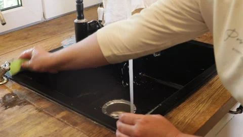 The process of cleaning a black kitchen sink Stock Footage 282472538