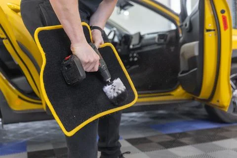 Process of cleaning a car mat by an automatic brush cleaner, car detailing Photos