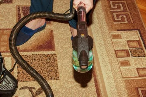The process of cleaning the carpet with a vacuum cleaner with a water filter. Stock Photos