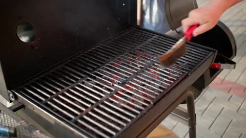 The process of cleaning the charcoal grill grates from burnt food residues wi Stock Footage 156344450