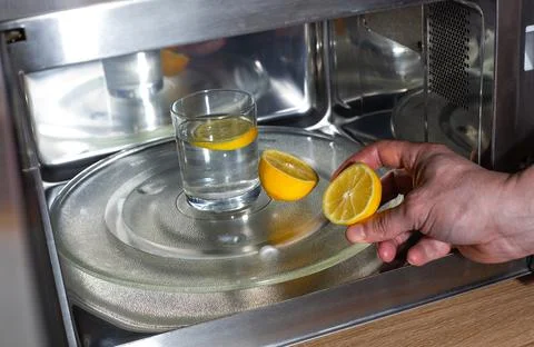 Process of cleaning or purifying the microwave oven by lemon and water Stock Photos