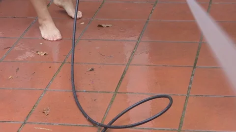 The process of cleaning terracotta tiles with a high-pressure washer. Water unde Stock Footage 296707359