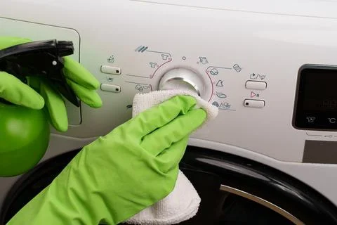 The process of cleaning a washing machine using a spray bottle and a wipe Fotos de archivo