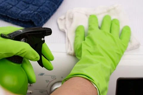 The process of cleaning a washing machine using a spray bottle and a wipe 스톡 사진