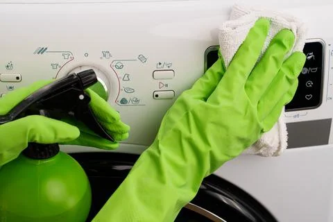 The process of cleaning a washing machine using a spray bottle and a wipe Stock-Fotos