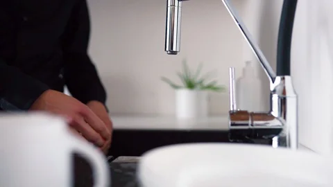 Process of cleaning white plate with sponge and hands. Guy stand at sink and Stock Footage 128908713