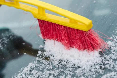 The process of cleaning the windshield of the car from the snow Stock Photos