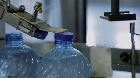 Process of closing plastic bottles with water in company. Stock Footage 81054255