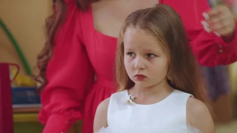 The process of combing a little girl, combing a girl in kindergarten Stock Footage 296493124