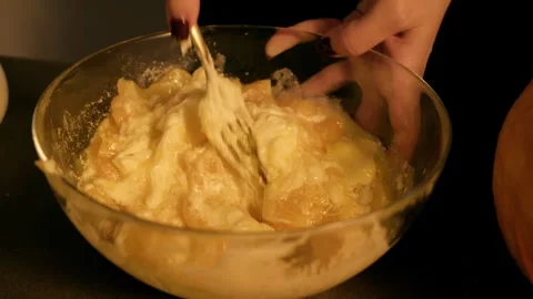 The process of combining cooked pumpkin dough and egg is captured closeup making Stock Footage 318937436