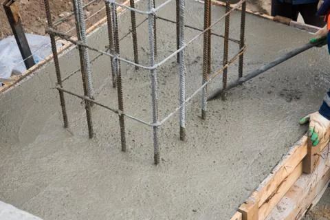 The process of compacting and smoothing fresh concrete. Concrete is poured in Stock Photos
