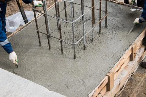 The process of compacting and smoothing fresh concrete. Concrete is poured in Stock Photos