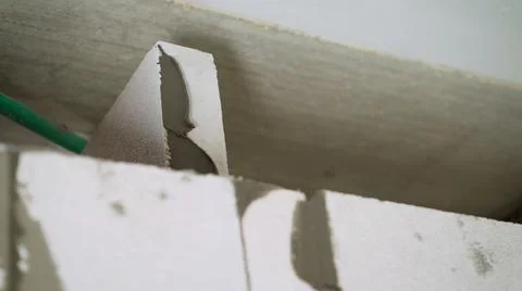 Process of construction house from the gas silicate block. A worker smears a  Stock Photos