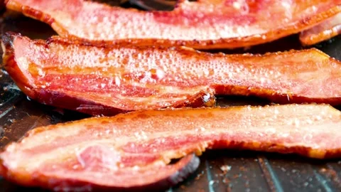 The process of cooking bacon slices on the grill. Chef grilling strips of bacon. 스톡 동영상 334641802