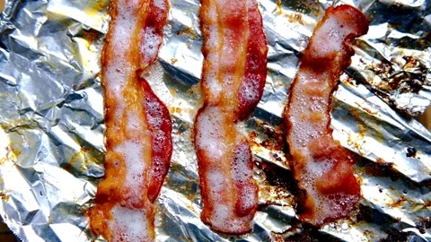 The process of cooking bacon slices on the grill. Chef grilling strips of bacon. 스톡 동영상 334641845