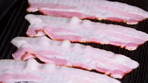 The process of cooking bacon slices on the grill. Chef grilling strips of bacon. 스톡 동영상 334641988