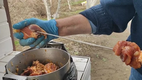 The process of cooking barbecue on a skewer, a man puts meat on a skewer Stock Footage 170694066