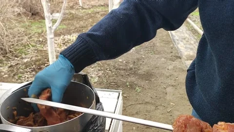 The process of cooking barbecue on a skewer, a man puts meat on a skewer Stock Footage 170694153