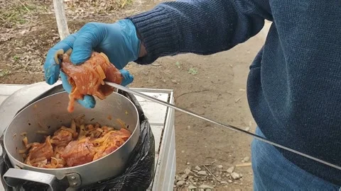 The process of cooking barbecue on a skewer, a man puts meat on a skewer Stock Footage 170694233