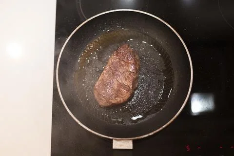 The process of cooking beef steak in a frying pan Stock Photos