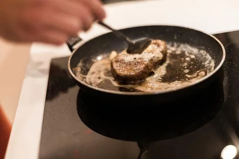 The process of cooking beef steak in a frying pan 写真素材