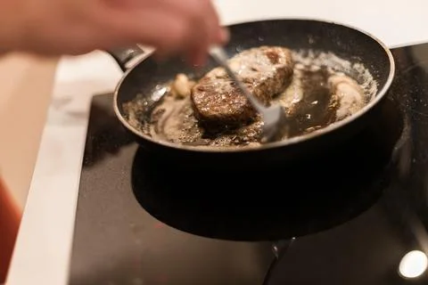 The process of cooking beef steak in a frying pan 写真素材