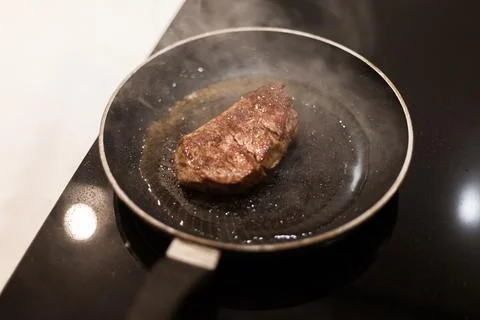The process of cooking beef steak in a frying pan Stock Photos