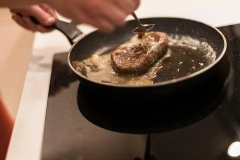 The process of cooking beef steak in a frying pan Stock Photos