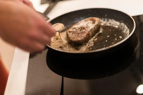 The process of cooking beef steak in a frying pan 写真素材
