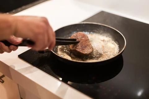 The process of cooking beef steak in a frying pan Stock Photos