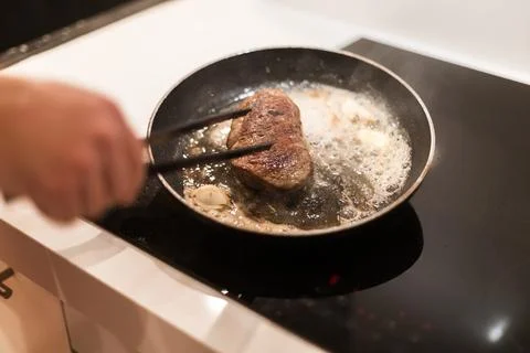 The process of cooking beef steak in a frying pan 写真素材