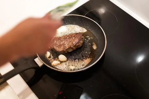 The process of cooking beef steak in a frying pan 写真素材