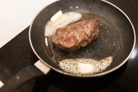 The process of cooking beef steak in a frying pan Stock Photos