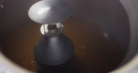 Process of cooking beer in brewery tank. Kettle with beer inside, flowing beer Stock Footage 148230219